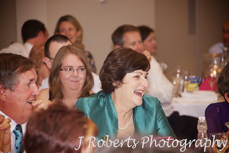 Mother of the bride laughing at speeches during wedding reception - wedding photography sydney